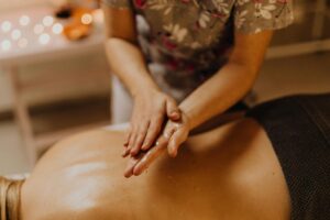 Close-up of therapist applying massage oil on a person’s back during a relaxing spa treatment